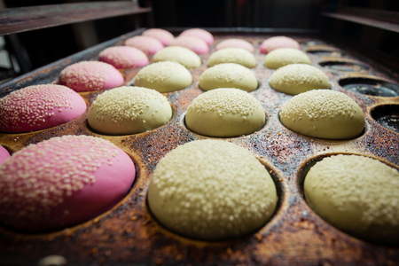 Multicolored buns for burgers on a baking trayの写真素材