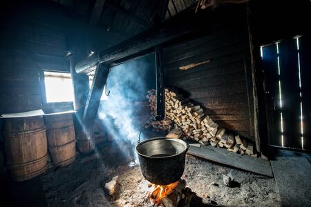 Cauldron on bonfire in a wooden house, cooking cheeseの写真素材