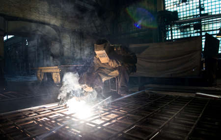 Closeup worker in a mask doing the welding in a workshop