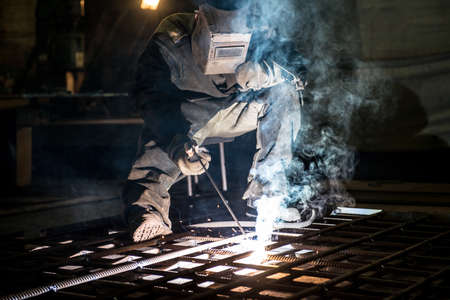 Closeup worker in a mask doing the welding in a workshop