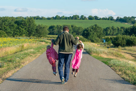 Father carries two children by the hands. Happy family.の写真素材