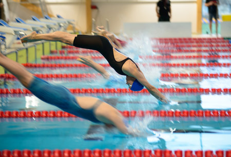 Women swimmers start from the starting table in the poolの写真素材