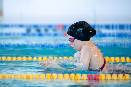 Swimmer girl swims breaststroke swimming style in the pool