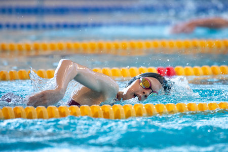 Swimmer girl swims freestyle swimming style in the poolの写真素材