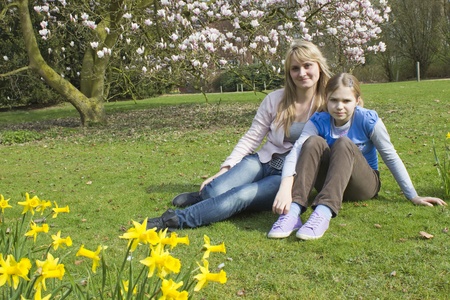 young woman and little girl in the park on a warm spring dayの写真素材