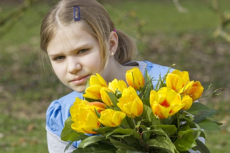 Little girl with tulips bouquetの写真素材