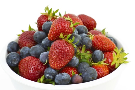 Strawberries and blueberries in a white bowlの写真素材