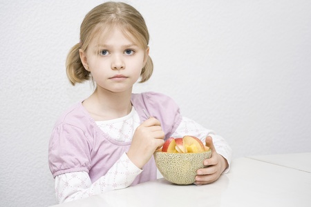girl eating fruit saladの写真素材