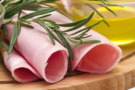 Rolled slices of ham, olive oil and rosemary の写真素材
