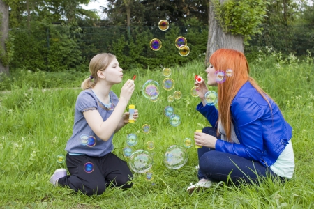 Little girl and young woman blowing soap bubblesの写真素材