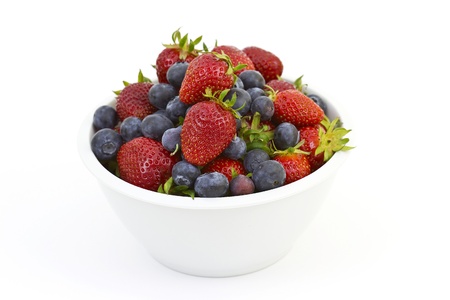 Strawberries and blueberries in a white bowlの写真素材