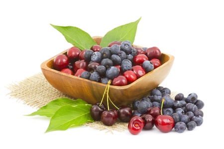 cherries and blueberries in a wooden bowlの写真素材