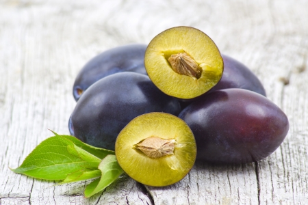 Fresh plums on old wooden backgroundの写真素材