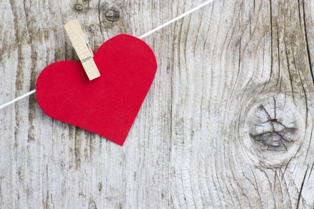 red heart hanging on line against old wood-grain wallの写真素材
