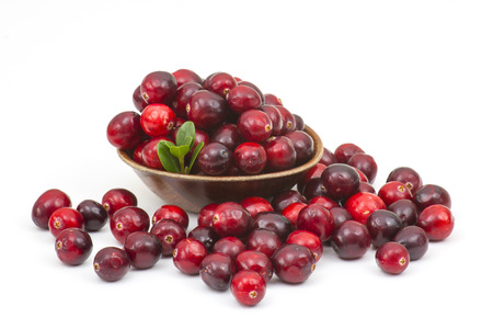 Cranberries in wooden bowl on white background.の写真素材