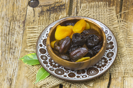 dried fruits in a bowl on wooden backgroundの写真素材