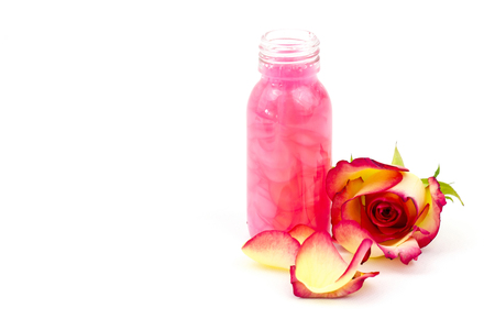 bath oil and pink rose on white backgroundの写真素材