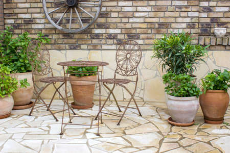 beautiful place in the garden in the mediterranean style, brick wall and pots with flowersの写真素材