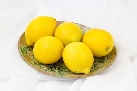 fresh lemons on a plate - white backgroundの写真素材