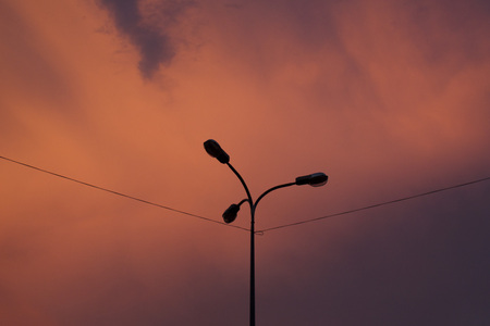 lonely lamppost on a background of scarlet sunset, electrification, modern technologiesの写真素材