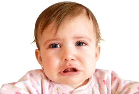 Crying little baby girl with watery blue eye detail isolated on white background.の写真素材