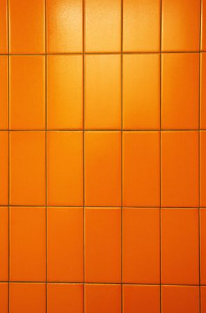 Orange tiles of a public bathroom wall. Great color and tiles also have orange peel texture.の写真素材