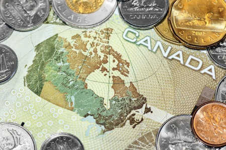 Close up of a one hundred canadian dollar bill showing the map of Canada, surrounded by loony and tuney coins.の写真素材