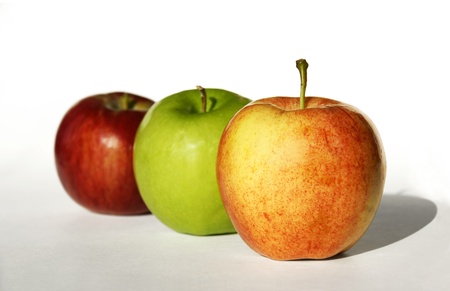 Delicious colorful healthy apple in a row on white textured background.