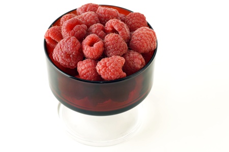 Vintage red glass filled with plumb raspberries, healthy and delicious fruits.