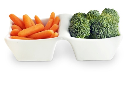 Healthy food choice from the vegetable garden: carrot and broccoli in cute white serving plate all on white background.の写真素材
