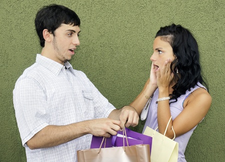 Consumerism concept: caught in th act, couple arguing about the young woman's many expensive purchases during her last shopping spree.の写真素材