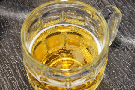 Looking down at the bottom of a glass bock filled with cold beer, addiction concept or refreshment and the likes.の写真素材