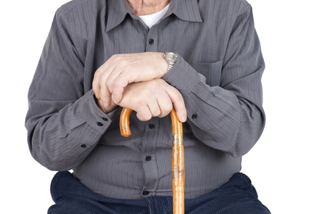 Great detail shot of senior man or elderly sitted and leaning on his cane, focus on hands.の写真素材