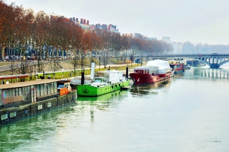 Damatic HDR rendering of a beautiful scene or landscape of houseboats or barges with their freight along the banks of the Rhone river, Lyon, France on a misty morning.の写真素材