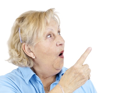 Funny senior woman with surprised face or in shock pointing with her finger at blank space beside her.の写真素材