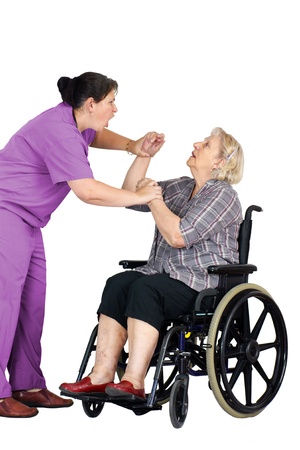 Elder abuse concept: enraged nurse or other healthcare provider assaulting a senior woman patient in a wheelchair, studio shot on white.の写真素材