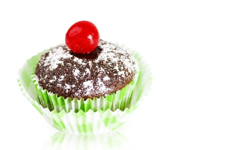 Delicious chocolate cupcakes topped with powdered sugar and maraschino cherry over white reflective background as copy space.の写真素材