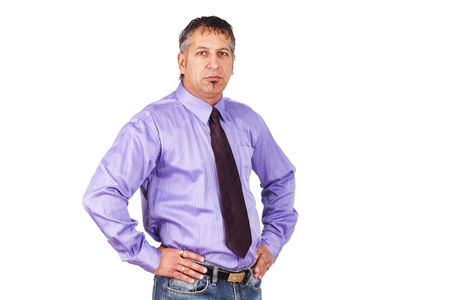 The guy at the office, disgruntled employee or grumpy boss, middle aged man with hands on hips looking mad or unhappy in shirt and tie with jeans.の写真素材