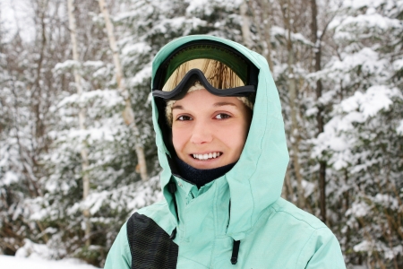 Candid portrait of a young caucasian woman wearing sky apparels enjoying the great outdoors or nature on a cold winter day.の写真素材