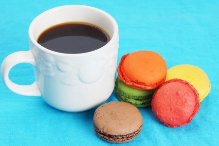 Cup of black coffee and colorful macarons on blueの写真素材