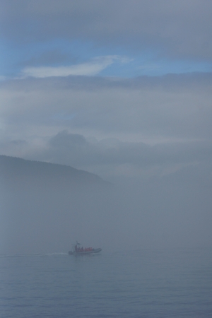 Inflatable boat with people on the St.Lawrence river on a very foggy dayの写真素材