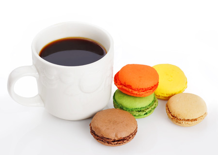 Delicious and colorful macaroons and a cup of black coffee on whiteの写真素材