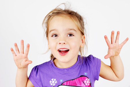 Cute, mischievous little blond girl playing tricksの写真素材