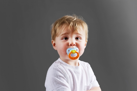 Cute little blond baby boy or toddler with pacifierの写真素材
