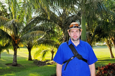 White tourist man posing in front of tropical palm treesの写真素材