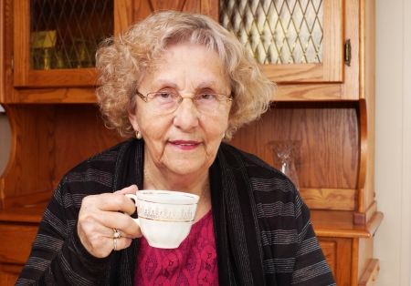Happy senior woman drinking tea at homeの写真素材