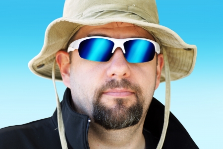 Portrait of a man during outdoor expedition with sun hat and mirror sunglassesの写真素材