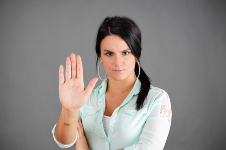 Dark haired woman making NO or STOP gesture with hand, concept      の写真素材