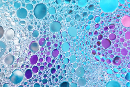 Oil and water over colorful blue and purple backgroundの写真素材