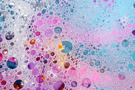Oil and water over colorful over pink, purple and blue backgroundの写真素材